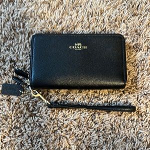 Like new Coach black wallet.  Two zipper openings and a removable hand strap.